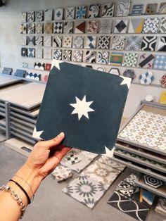 a person holding up a piece of black and white tile