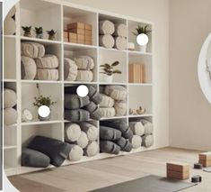 a room filled with lots of white and grey items in front of a round window