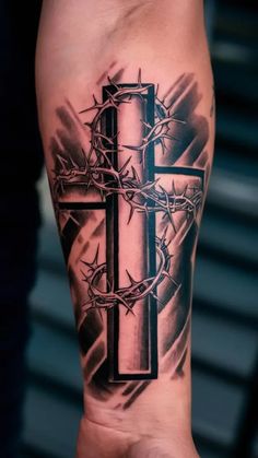 a black and white tattoo with a cross on it's arm, surrounded by barbed wire