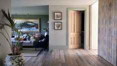 a living room filled with furniture and a painting on the wall next to a doorway