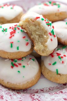 a plate full of cookies with white frosting and sprinkles