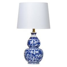 a blue and white vase lamp with a white shade on the top, sitting in front of a white background