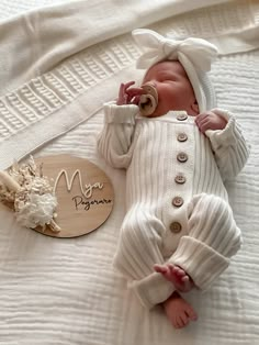 a baby doll laying on top of a white blanket