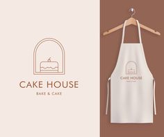 a cake house logo on a white and brown background next to a wooden hanger