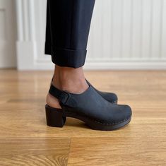 The Daphne block heel clog has a 2" heel and a secure buckle strap. This style comes in 4 classic colors, monochrome black, whiskey, cedar and kelp. Clogs Outfit, High Heel Clogs, Platform Clogs, Clog Heels, Sock Shop, Papua New Guinea, Turks And Caicos Islands, Trinidad And Tobago, Uganda