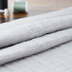 two folded towels sitting on top of a wooden table