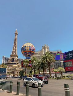 the eiffel tower is in the distance, and cars are parked on the street