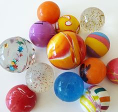 an assortment of colorful marbles on a white surface with speckles and sprinkles