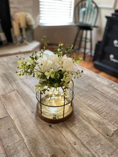 a vase filled with white flowers on top of a wooden table