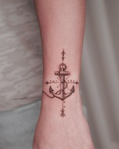 a small anchor tattoo on the foot of a woman's right hand and wrist