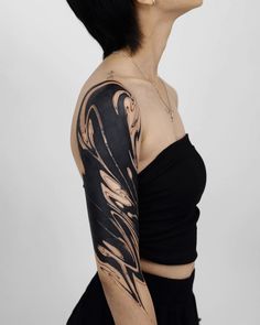 a woman with black hair and tattoos on her arm