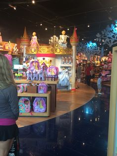 a woman standing in front of a store filled with toys