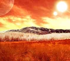 an image of the sun setting over a mountain range with grass in front of it