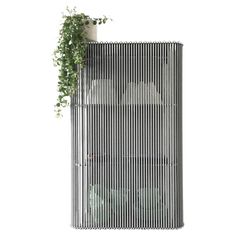 a tall metal structure with a plant growing out of it's top part, against a white background