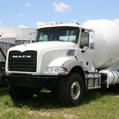 a large white truck parked on top of a grass covered field