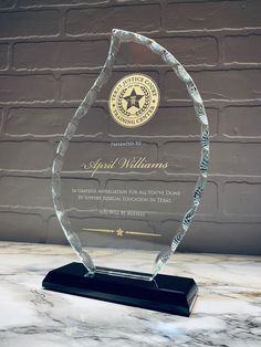 an award is displayed on a marble countertop with a brick wall in the background