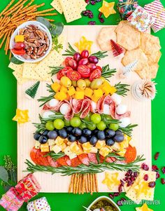 a christmas tree made out of fruits and vegetables on a cutting board with crackers