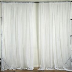 two white curtains with black poles in front of them