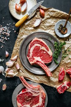 two pieces of raw meat on a plate next to garlic, pepperoni and other ingredients