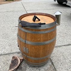 a wooden barrel sitting on top of a sidewalk