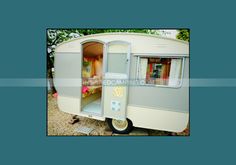 an old camper trailer with its door open