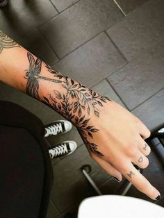 a woman's arm with tattoos on it and her hand in the middle of the photo