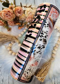 a pink, black and white case sitting on top of a table next to flowers