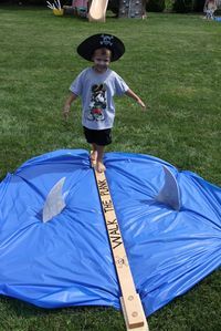 a young boy standing on top of a blue tarp