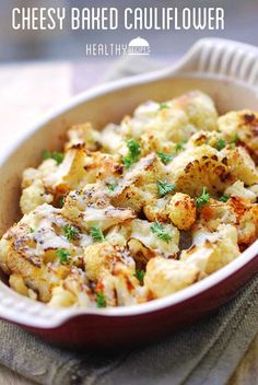 a casserole dish with cauliflower and parsley in it on a table