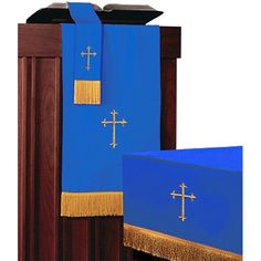 the cross on the blue cloth is next to the wooden podium with gold fringes