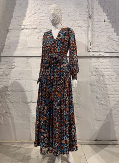 Stunning vintage 1970s maxi dress floral allover pattern if orange, rust, white and turquoise on navy background   v-neck bishop style sleeve with covered button closure at cuffs pleated skirt matching belt dress is fully lined apart from sleeves zip at rear great vintage condition no composition label  lining acetate size 36 please refer to measurements armpit to armpit 44.5 cm shoulder to shoulder 38.5 cm sleeve  waist 34.5 cm hip free 63 cm length 143 cm If you have any other questions please Orange Floral Print Long Sleeve Maxi Dress, Fall Floral Print Orange Maxi Dress, Retro Floral Print Maxi Dress For Fall, Fall Retro V-neck Maxi Dress, Maxi Dress Floral, Allover Pattern, Belt Dress, Navy Background, Bishop Sleeve