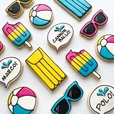 decorated cookies are arranged in the shape of beach scenes and sunglasses on a white surface