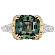 This ring is a stunning piece that combines elegance with uniqueness. The 4.50 carat cushion-cut Green Sapphire at the center is not only impressive in size but also comes with a GIA certification, ensuring its quality and authenticity. The green hue adds a rare and captivating touch. The center green sapphire is flanked by 0.24 carats round yellow diamonds and set in yellow gold. An additional 0.36 carats white diamonds decorate the side shank. All these combine to create a visually striking an Green Montana, Gem Rings, Brilliant Cut Diamond Ring, Green Sapphire Ring, Great Yarmouth, Yellow Diamonds, Buying An Engagement Ring, Ring Inspo, Fine Diamond Jewelry