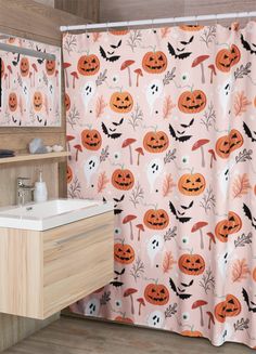 a halloween themed bathroom with pumpkins on the shower curtain