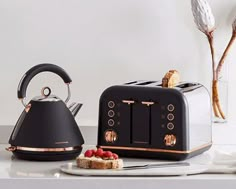 two toasters sitting next to each other on top of a white counter with silver and gold accents