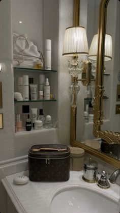 a bathroom sink with a mirror above it and a suitcase on the counter in front of it