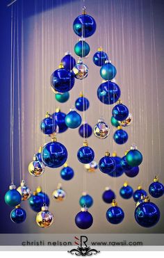 a blue christmas tree with ornaments hanging from it