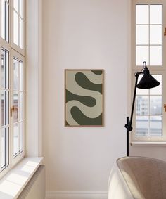 a painting hanging on the wall next to a window in a room with white walls