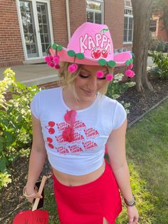 a woman wearing a pink hat and red skirt