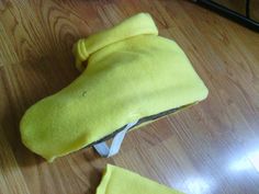 a stuffed animal is laying on the floor with it's head covered by a yellow cloth