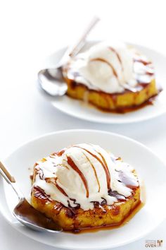 two white plates topped with desserts covered in ice cream and caramel sauce on top