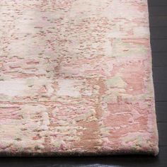 a pink rug with an abstract design on the top and bottom, sitting on a wooden floor