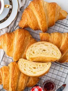 croissants on a cooling rack next to a cup of coffee