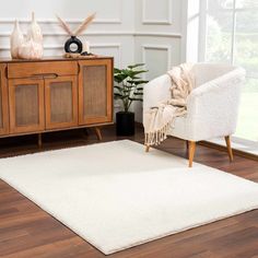 a living room with a white rug on the floor and a chair in front of it