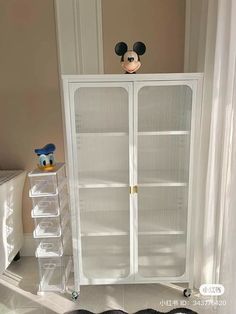 a mickey mouse head on top of a white cabinet