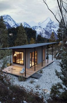 a small house with mountains in the background