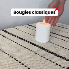 a person holding a candle on top of a rug with the words bougies classiques