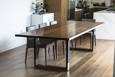 a kitchen with a table and chairs next to a counter top in the middle of it