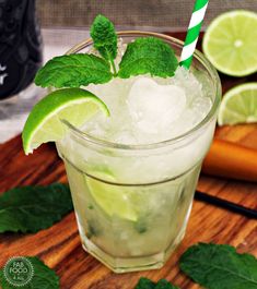 a mojito cocktail with lime and mint garnish on a cutting board