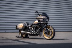 a gold and black motorcycle parked in front of a metal garage door on the street